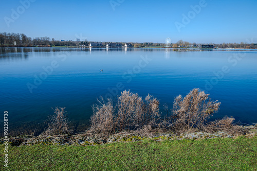 Willen Lake in early spring under a clear cold blue sky, with calm blue water and a refreshing, tranquil atmosphere in Milton Keynes green space A