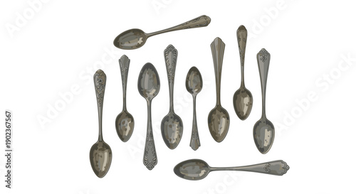 Collection of Antique Silver Spoons with Ornate Handles Arranged on Clean White Surface in Studio