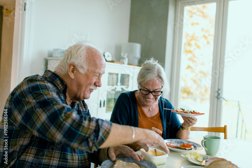 Smiling senior couple preparing lunch at home