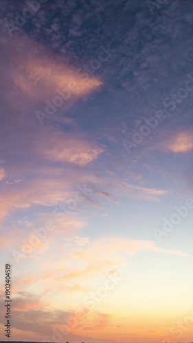Soft pastel shades with scattered clouds, Tranquil sunset sky with warm pastel cloudscape, Calm evening atmosphere featuring pink and blue hues across expansive horizon