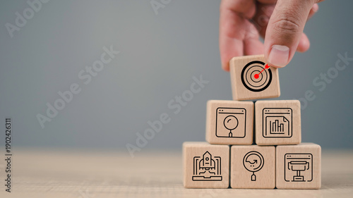 Hand stack wooden blocks with marketing icons and target, representing customer segmentation, CRM strategy, business success, advertising planning, and identifying target audience for growth.