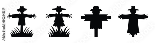 A set of scarecrow silhouettes standing in a field at dusk silhouette