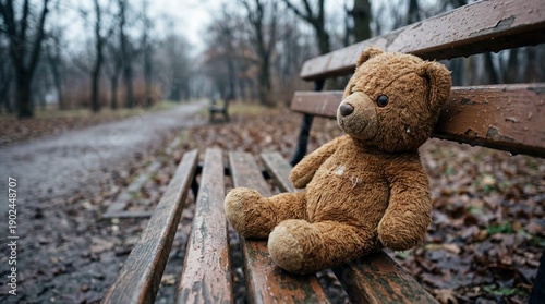 Child’s forgotten teddy bear lying on an empty bench