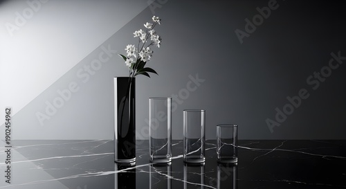 Elegant glass sculpture on a reflective surface with multiple thin vases