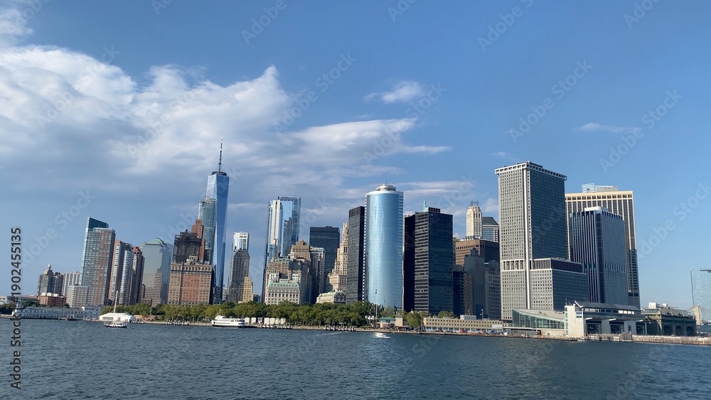 Obraz premium Lower manhattan skyline featuring one world trade center. Modern skyscrapers. And historic buildings rising above the tranquil hudson river under a clear sky