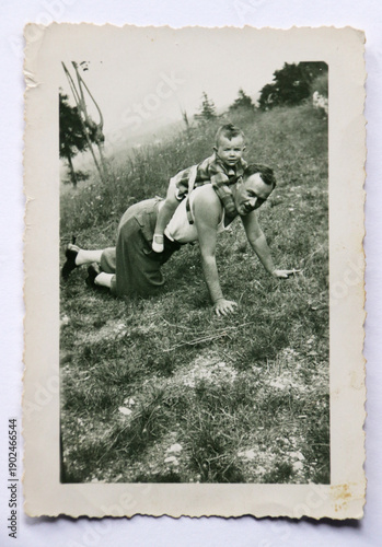 FOTOGRAFIA ANTICA CON UN PADRE E UN PICCOLO FIGLIO GIOCANDO SUL PRATO