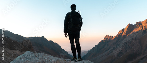 Traveler looks at beautiful sunset among the mountains.