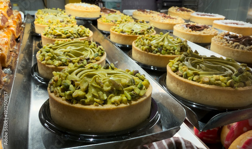 Photos Display case with Italian tarts with green cream and crushed pistachio