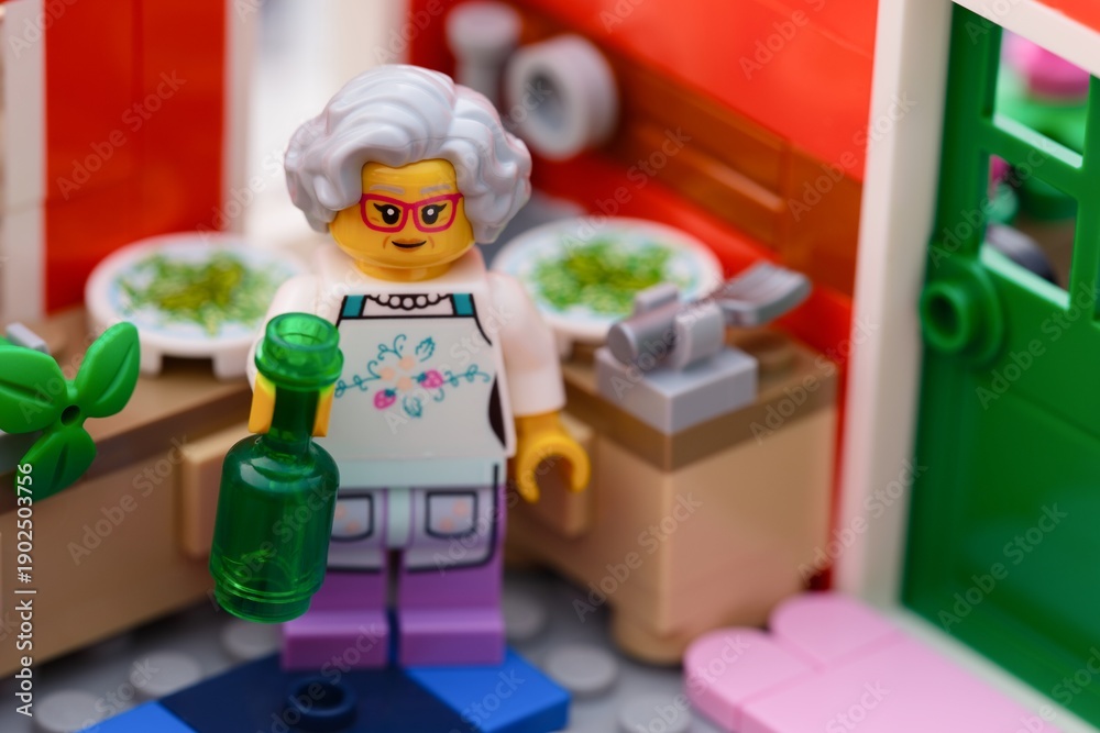 Fototapeta premium Tambov, Russian Federation - January 27, 2026 Lego grandmother minifigure in an apron with green bottle cooking in his kitchen.