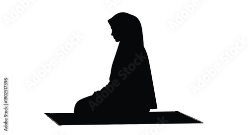 A kneeling woman in traditional islamic attire a striking silhouette