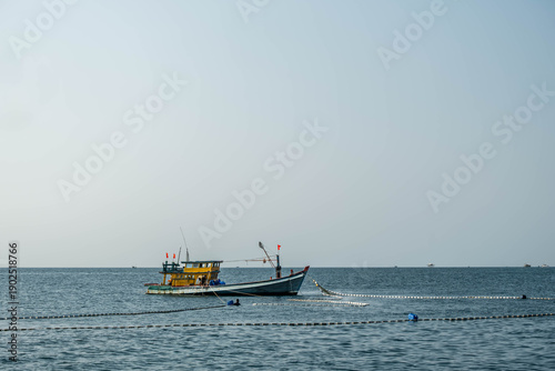 Foto Vietnamese fishermen working with nets from a traditional fishing boat in the ca
