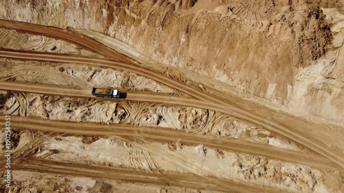 Static aerial view of moving dump truck in sand quarry
