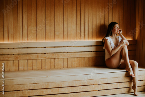 Woman sits in a sauna durin...