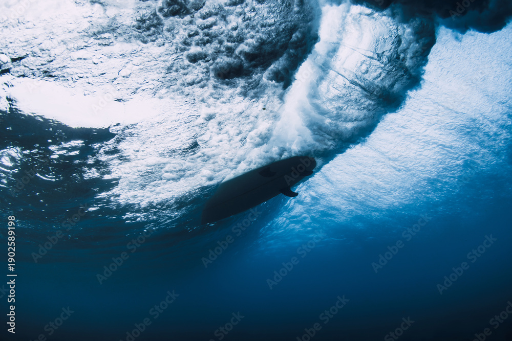 Fototapeta premium Surfer carving inside powerful wave, underwater perspective of ocean force and extreme sport.