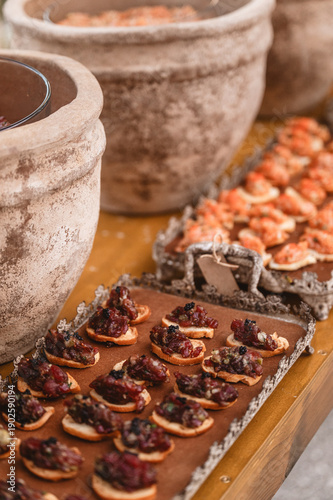 Trays with differents kinds of canape with some old ceramics around it.