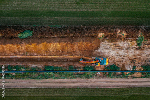 Aerial View of Excavator Digging Trench for Pipeline Construction