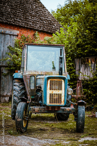 Old Vintage Tractor Parked on Rural Farmyard Near Barn