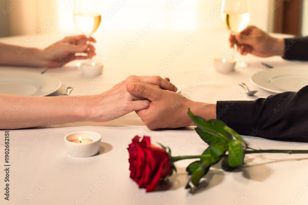 © kieferpix - Couple Holding Hands at Romantic Candlelight Dinner, Intimate Dinner Date with Love, Wine, and Red Rose