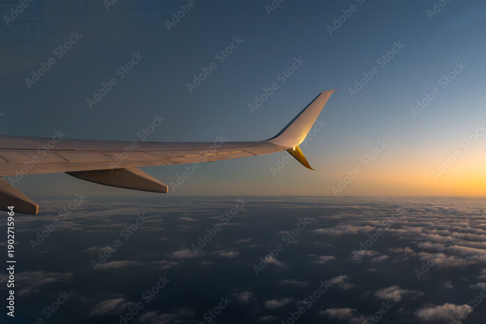 Fototapeta premium view from airplane window. sunset over the clouds