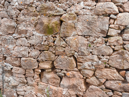 Tableau sur toile Detail of a rustic stone wall with a haphazard, irregular arrangement of stones, showcasing texture and natural patterns