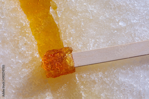 Maple syrup hardening on fresh snow to create maple taffy