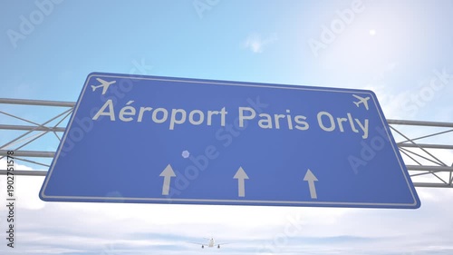 Highway direction sign for Paris Orly Airport with passenger jet lowering toward the airport, arriving to Paris, France.