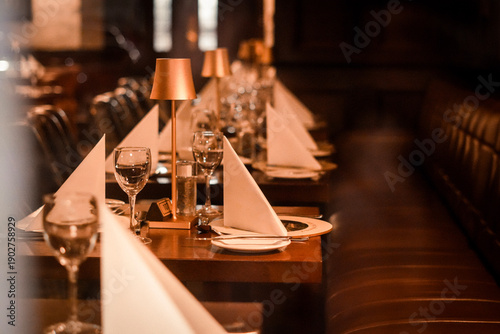 Fotografie Elegant restaurant interior with a long table set for dinner, neatly folded whit