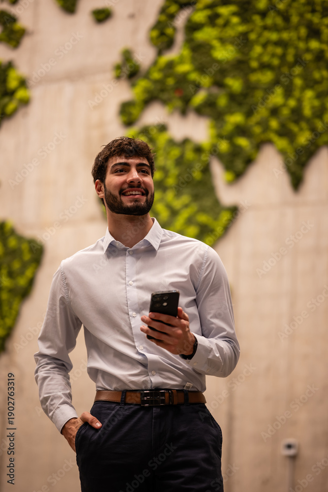 Obraz premium Young professional using smartphone with world map background