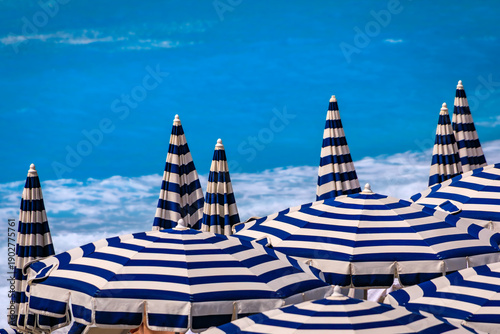 Εκτύπωση καμβά Striped umbrellas on a beach along Promenade des Anglais with the turquoise wate