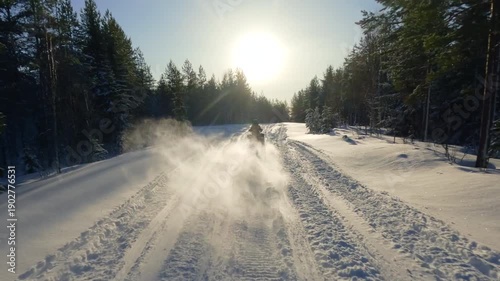 Thrilling POV footage of a snowmobile speeding through a snowy forest trail in Sweden, kicking up powder as the sun sets between the pine trees, creating a beautiful lens flare, , real sound