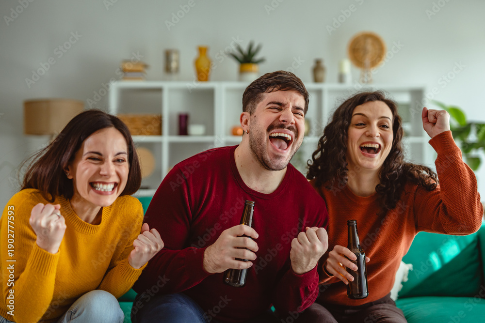 Obraz premium Group of friends celebrating victory while watching sports