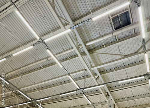 Modern Industrial Aesthetics. Spacious Ceiling Showcasing Raw Building Materials. Creative Architectural Approach Highlighting Industrial Materials And Exposed Lighting Fixtures