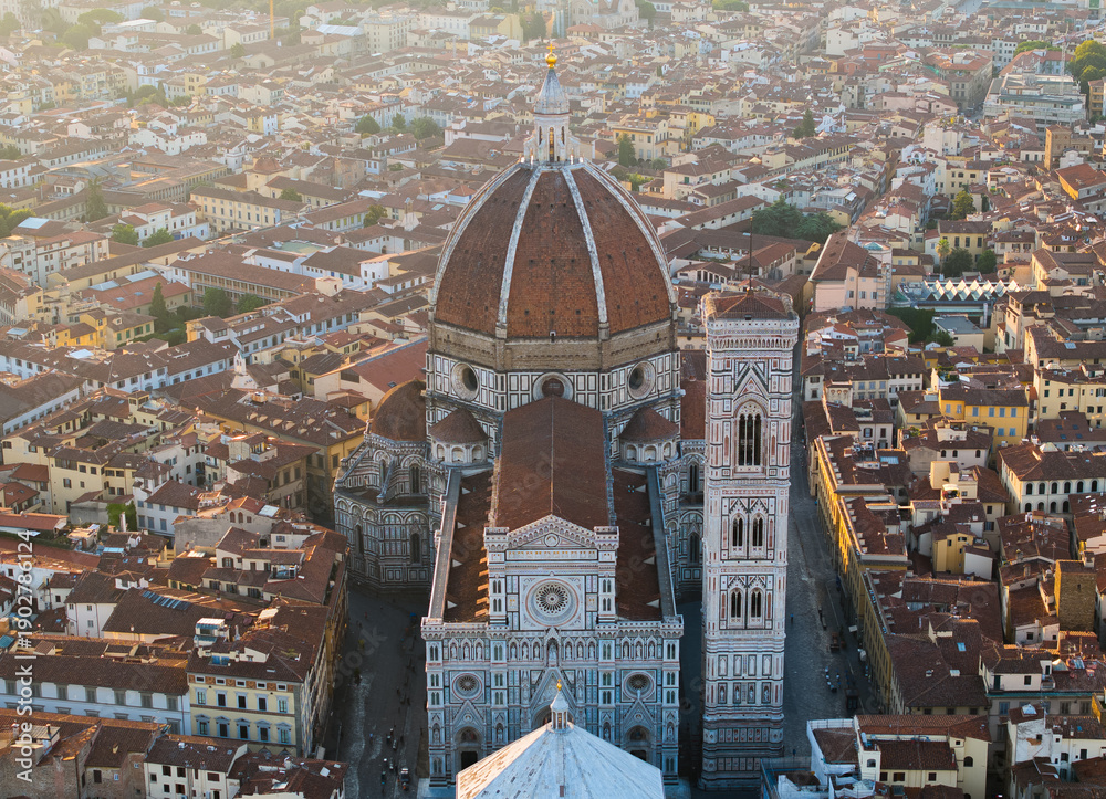 Obraz premium Aerial view of Florence historic city center at sunrise, highlighting the Duomo and dense urban fabric illuminated by soft golden morning light in Italy