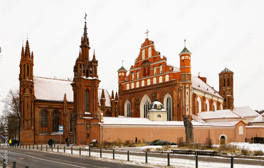 Fototapeta premium Vilnius, Lithuania. View of roman catholic church of St. Anne and Church of St. Francis and St. Bernard In Old Town in winter day