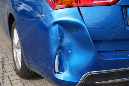Bilde på lerret Severely dented rear bumper and body panel on a blue car showing collision damag