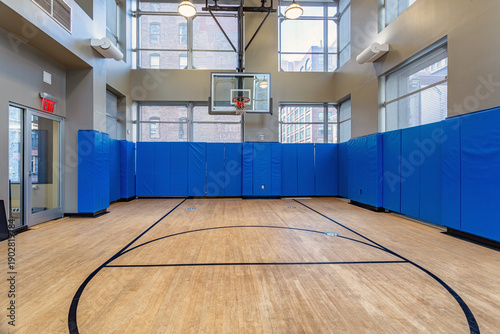 Εκτύπωση καμβά Empty indoor basketball court with hardwood floor and blue padded walls