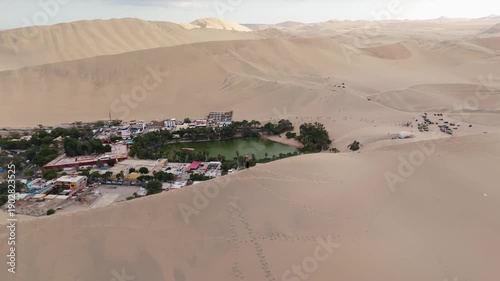 Aerial view of Huacachina oasis in Peru, showcasing sand dunes and a tranquil lake