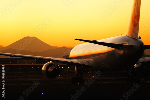 Foto 夕日を浴びて富士山に向かってタキシングする航空機