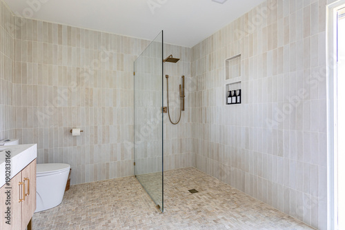 Fotografía Modern walk-in shower bathroom with glass partition and neutral tile interior