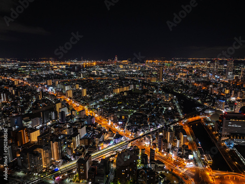 Wallpaper Mural Aerial perspective of Osaka's nighttime cityscape, featuring illuminated streets, buildings, and a lively urban horizon of this Japanese metropolis Torontodigital.ca
