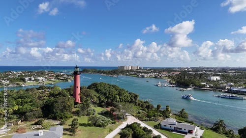 Flying by Jupiter lighthouse with boat traffic at Jupiter Inlet in Palm Beach County, Florida. 