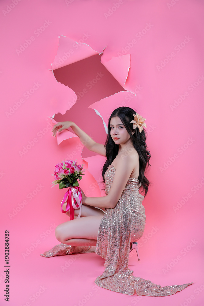 Fototapeta premium Creative Valentine portrait of beautiful Asian woman with pink roses through torn pape