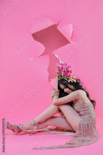 Creative Valentine portrait of beautiful Asian woman with pink roses through torn pape
