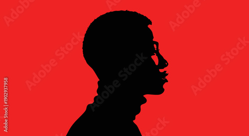 Silhouette of a person wearing glasses against a vibrant red background.