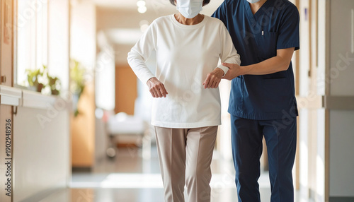 病院で理学療法士と歩くリハビリをする高齢女性　シニア介助イメージ