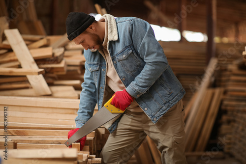 Male carpenter sawing woode...