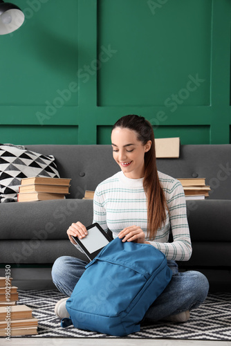 Young girl putting e-reader...