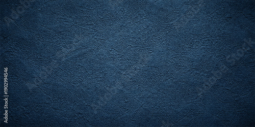 A dark blue leather and denim fabric material texture with a rough macro pattern surface for a grunge textile wallpaper design backdrop