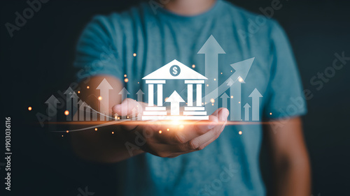 Man Holding Bank Building with Growing Financial Graph on Hand