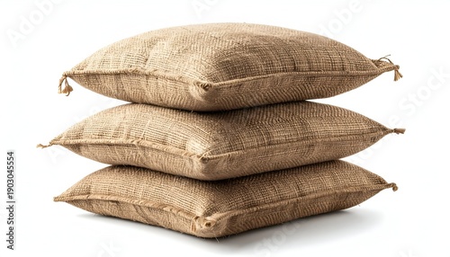 Stack of three burlap pillows, tan color, isolated against a white background